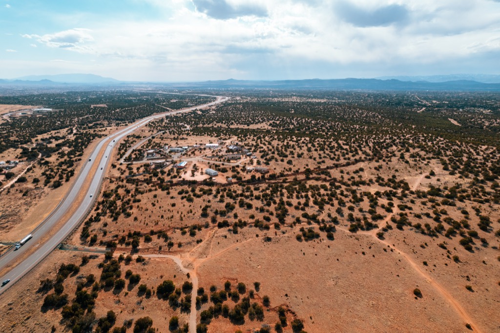 Aerial view over the New Mexico desert with distant mountains faded to gray-blue by atmospheric haze